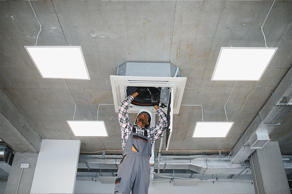 Com HVAC tech fixing vent